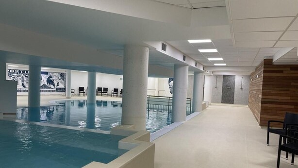 An indoor swimming pool with clear water, surrounded by columns and a tiled floor. - 150m from ski slopes, 3rd floor, swimming pool, terrace, tv, ski locker, 49m², Gourette (Eaux-Bonnes)