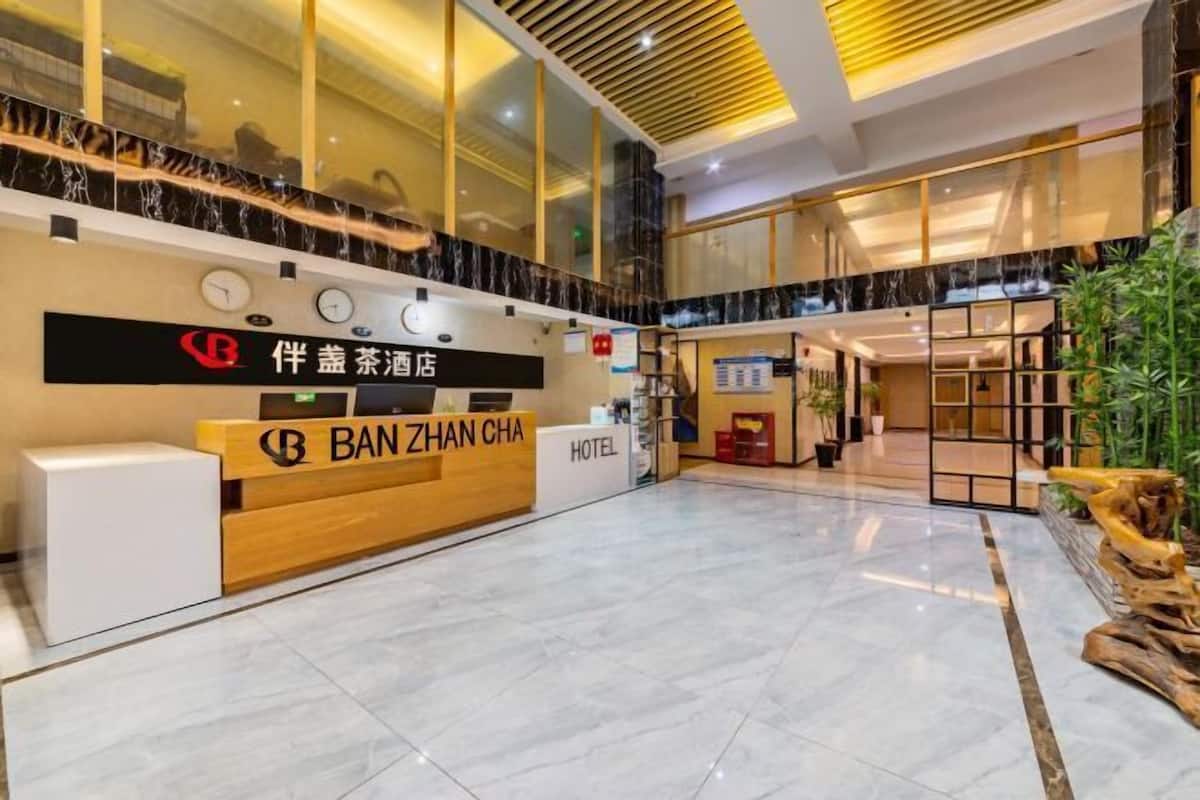 A hotel reception area with a modern design, featuring a reception desk labeled "BAN ZHAN CHA HOTEL" and a sign indicating the hotel's name in Chinese.