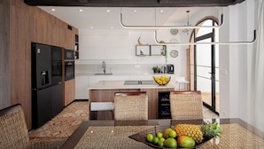 Une cuisine moderne avec des meubles en bois, un four encastré et un îlot central doté de sièges.