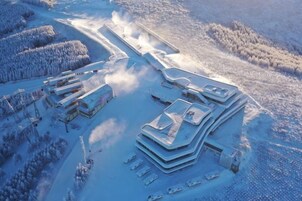 Un complejo de edificios cubierto de nieve, con varias estructuras, incluyendo un edificio central con techo curvo y varios edificios más pequeños a su alrededor.