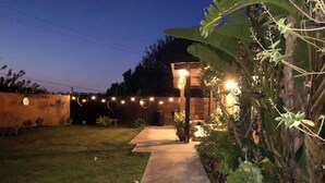 A pathway leading to a building with string lights and heart-shaped decorations. - Casa Alquimia-Chula Vista Home, Private patio. (Chula Vista)