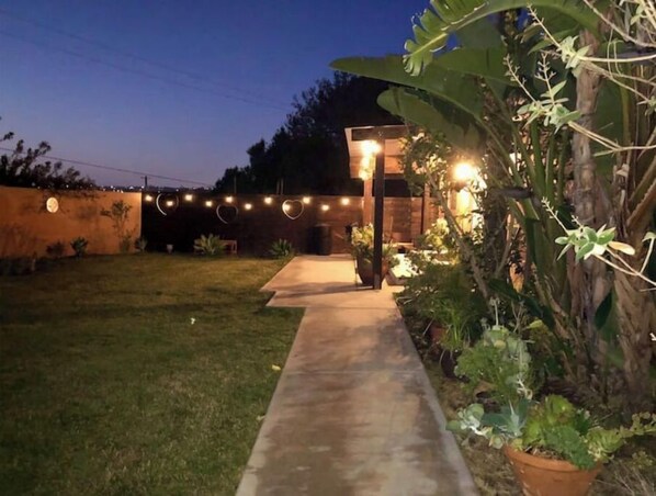 A pathway leading to a building with string lights and heart-shaped decorations.