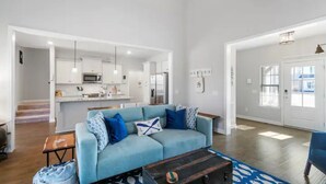 A spacious living area with a light blue sofa, a wooden coffee table, and a kitchen in the background. - Tims Ford Lake Retreat - The Got-Away (Tullahoma)