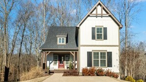 A two-story house with a front porch, a small attached garage, and a driveway leading to the entrance. - Tims Ford Lake Retreat - The Got-Away (Tullahoma)