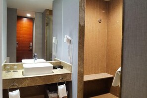 A bathroom with a sink, mirror, and a shower area. - Tianying Hotel (Dongguan)