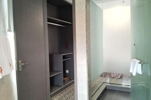 A bathroom with a glass shower enclosure, a towel rack, and a patterned floor. - Tianying Hotel (Dongguan)