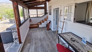 Eine Holztreppe führt zu einem Balkon mit Blick ins Freie.
