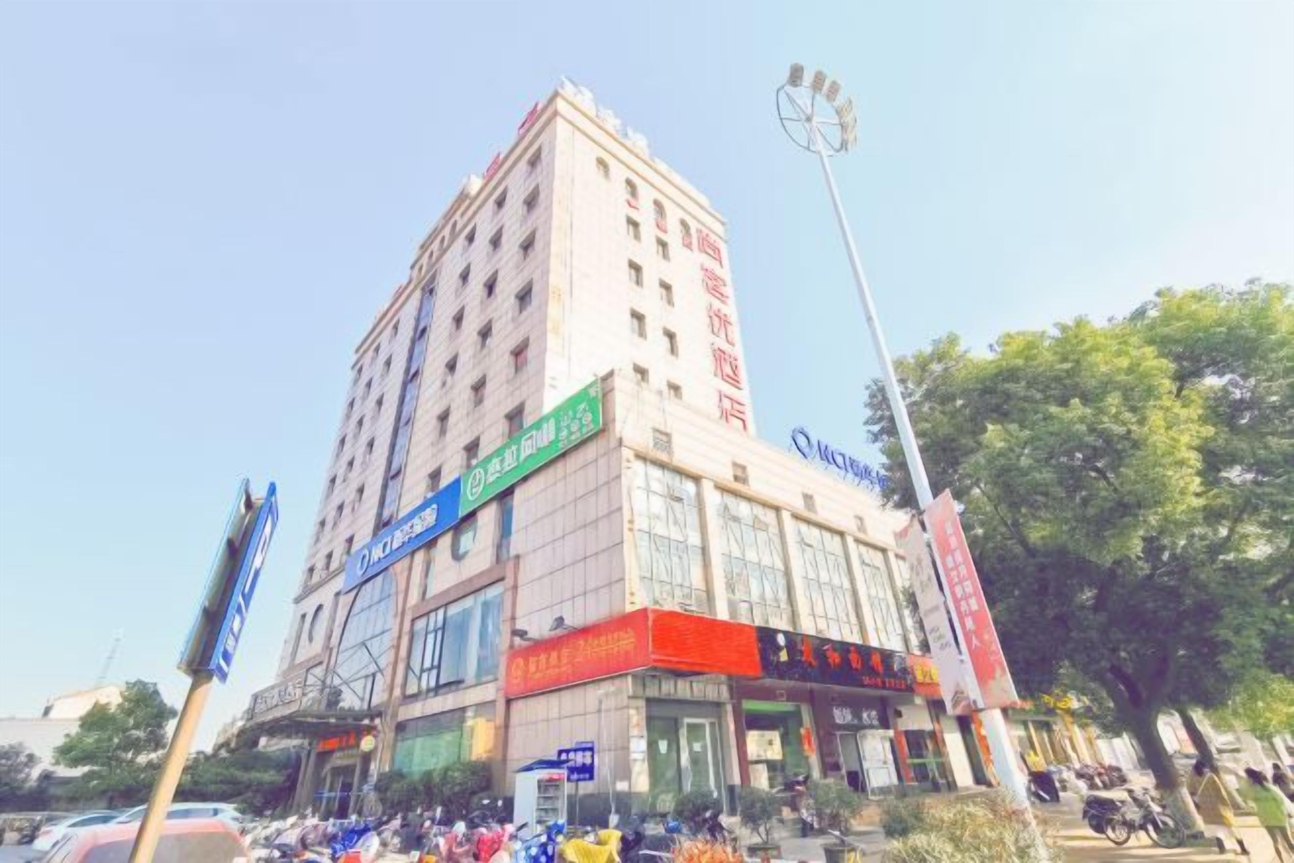 A multi-story building with signage for a hotel and various businesses.