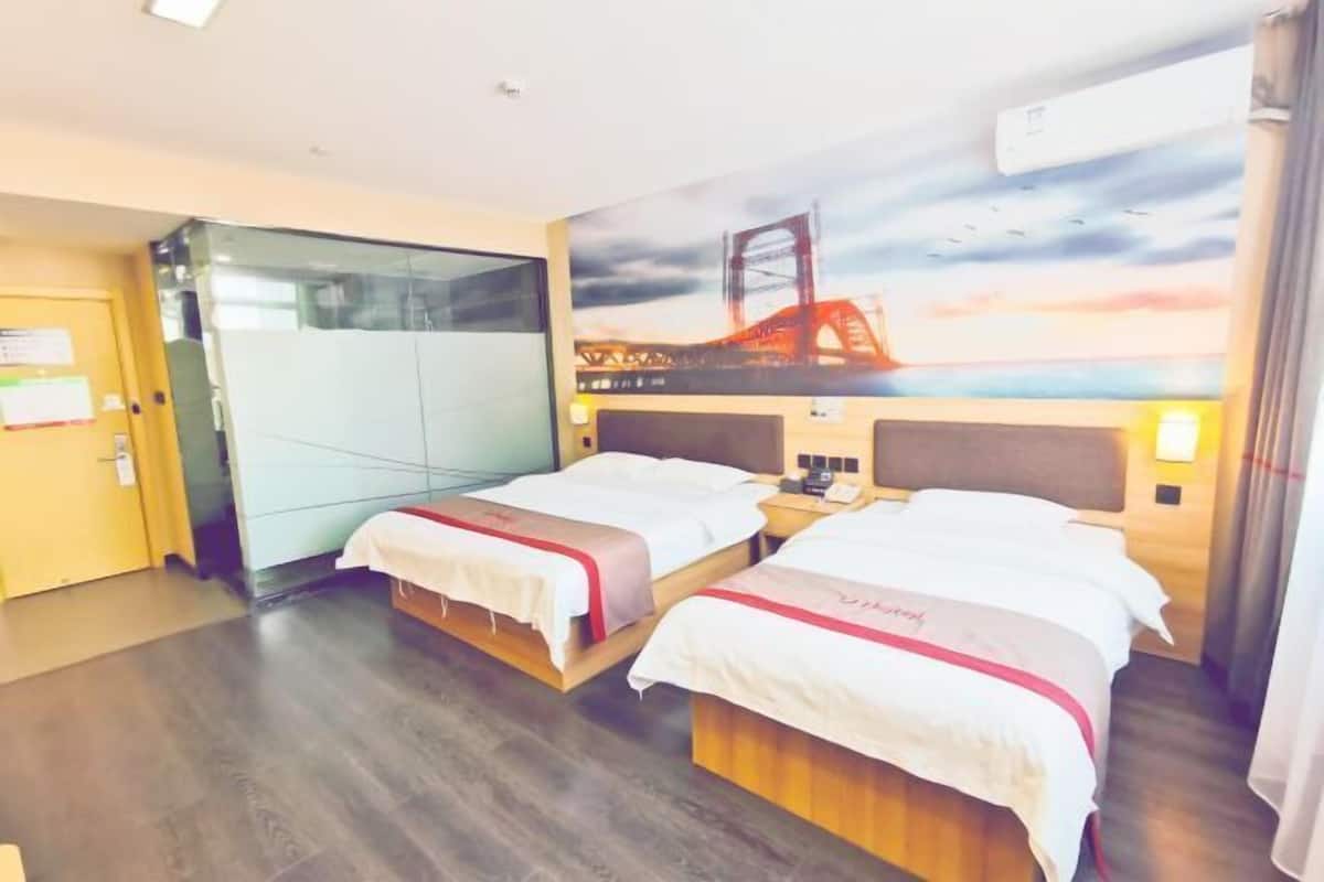 A hotel room with two beds, a painting of a bridge, a wooden headboard, and a nightstand with a phone.