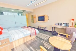 Een hotelkamer met een bed, een bureau, een stoel en een klein tafeltje.