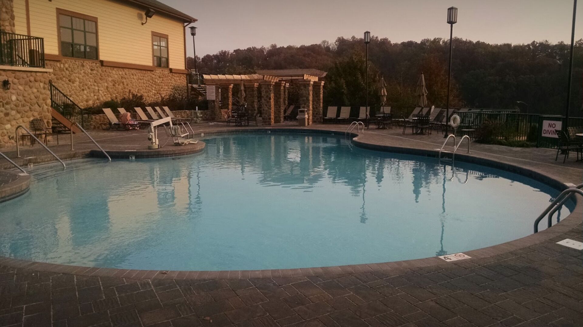 Une piscine avec des chaises longues et un espace salon abrité.