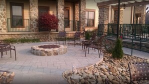 A courtyard with stone walls, outdoor seating, and a fire pit. - 2BD/Sevierville - Smoky Mountains Resort w/pools! (Sevierville)