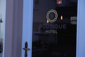 A hotel entrance with a door handle and a logo with the letter 'B' and the words 'BOUTIQUE HOTEL'. - Boutique Hotel (Bad Salzuflen)