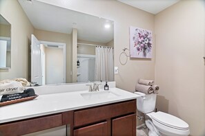 A bathroom with a white sink, a mirror, a toilet, and a shower curtain. - 8 minutes from Las Vegas strip this is the best location to move around (Las Vegas)