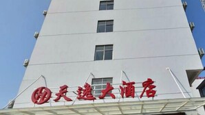 A hotel with a modern facade, a prominent red sign, and a covered entrance. - Tianyi Hotel Zhangjiajie (Zhangjiajie)
