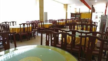 Un comedor con varias mesas y sillas dispuestas en filas.