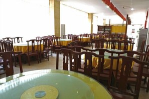 Un espace repas comprenant plusieurs tables et chaises, disposées en rangées.