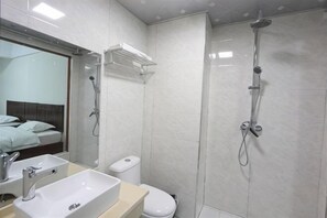 A bathroom with a sink, toilet, and shower. - Tianyi Hotel Zhangjiajie (Zhangjiajie)