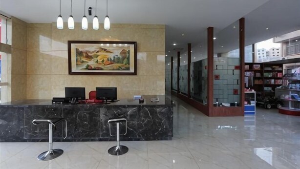 A reception area with a marble counter, two bar stools, a painting, and a glass wall. - Tianyi Hotel Zhangjiajie (Zhangjiajie)