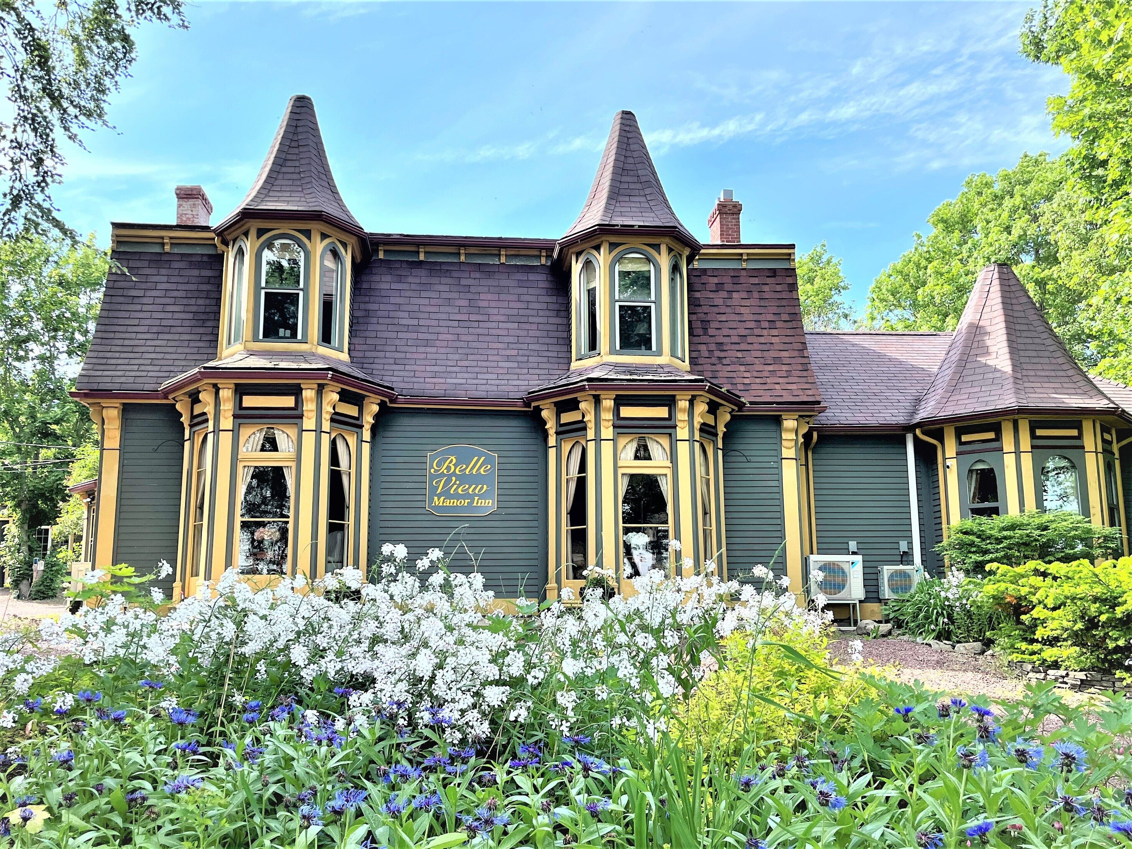 A Victorian-style building with a sign reading "Belle View Manor Inn."