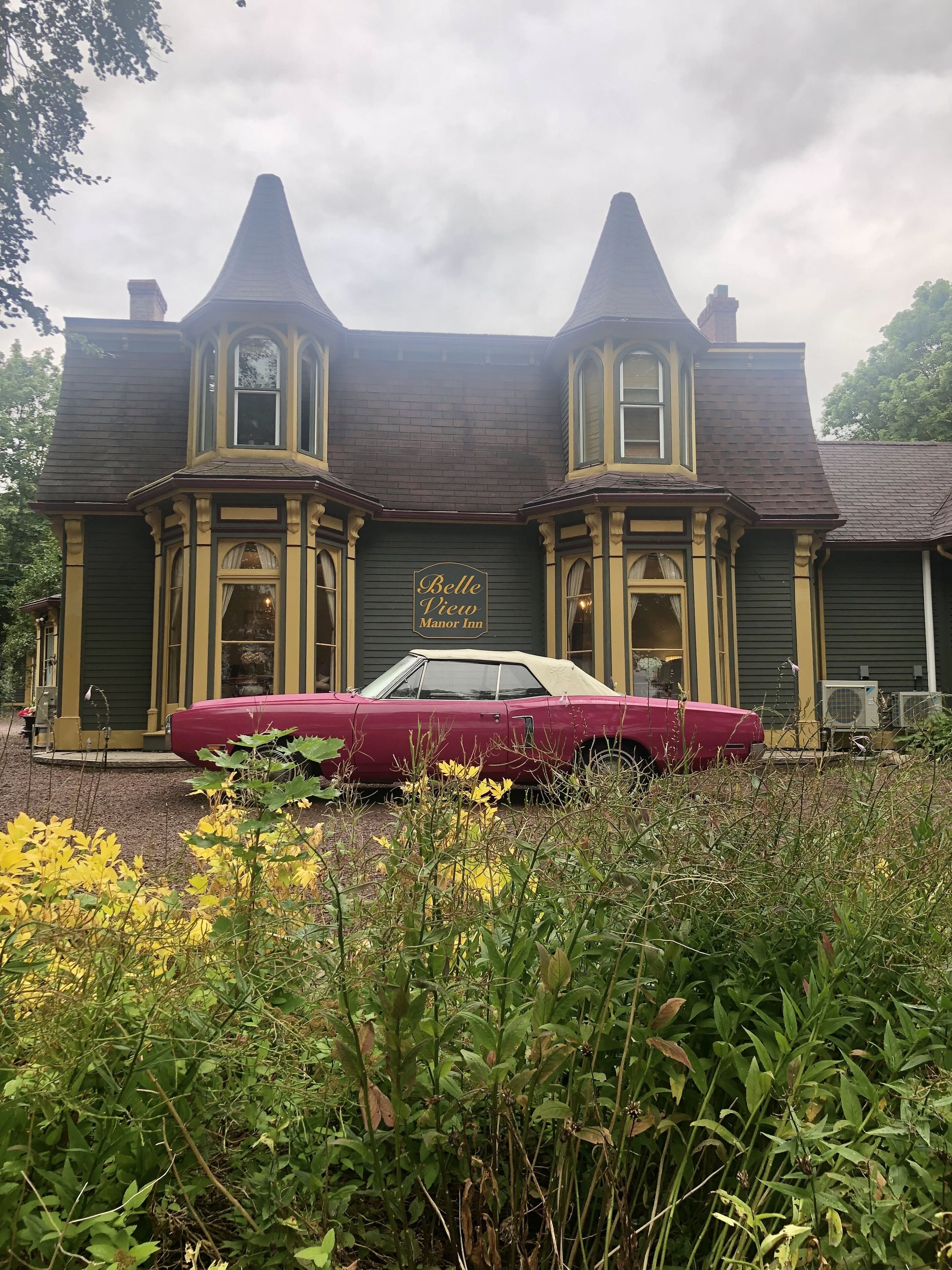 Um edifício grande e histórico com uma placa que diz 'Belle View Manor Inn'.