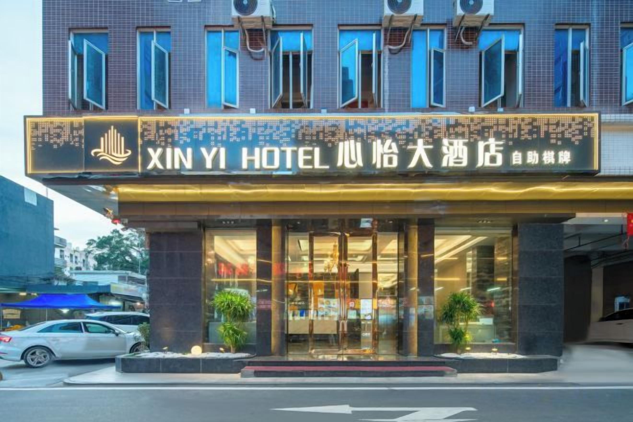 Een hotel met een opvallende ingang, grote glazen deuren en een bord met Chinese karakters.