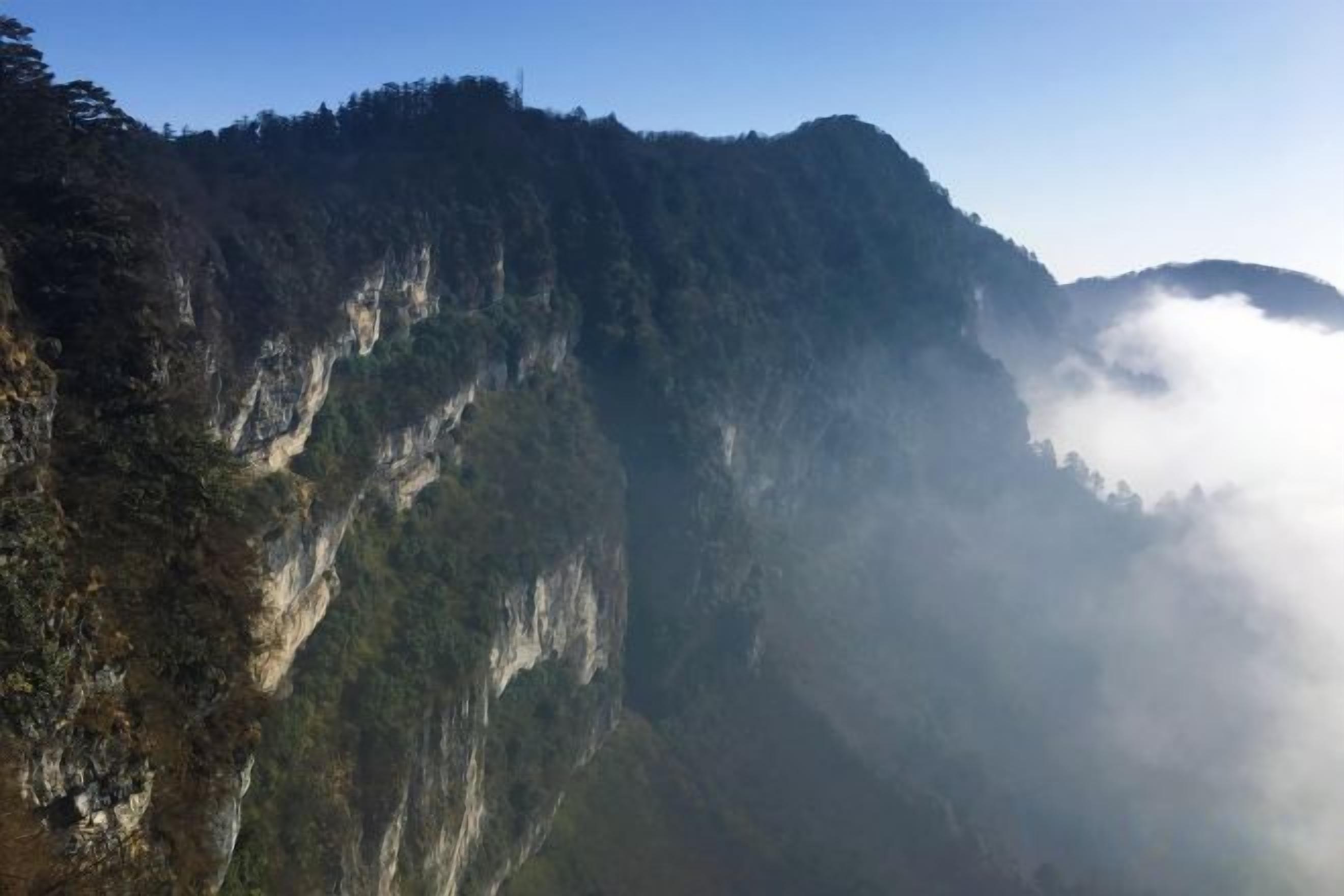 Un paisaje montañoso con acantilados escarpados y una zona boscosa.