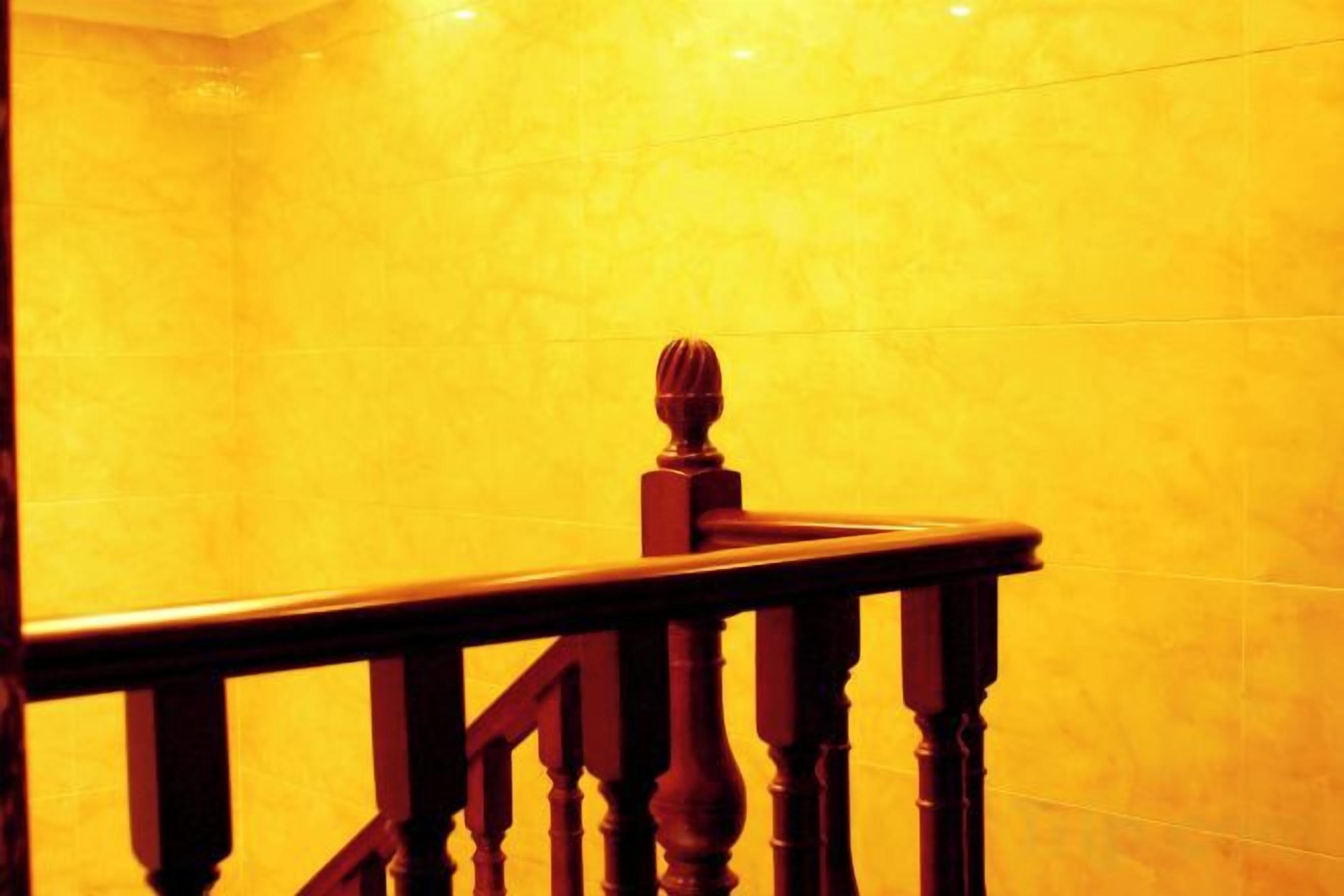 A wooden staircase with a balustrade leading to a higher floor.