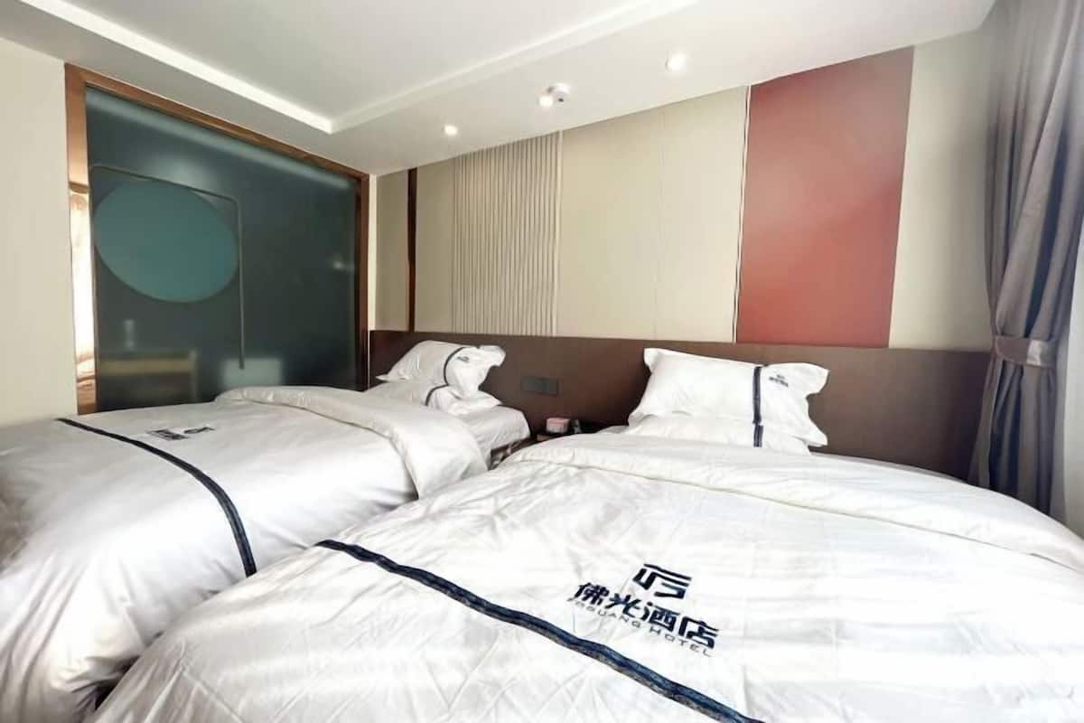 A hotel room with two beds, a large mirror, and a modern design.