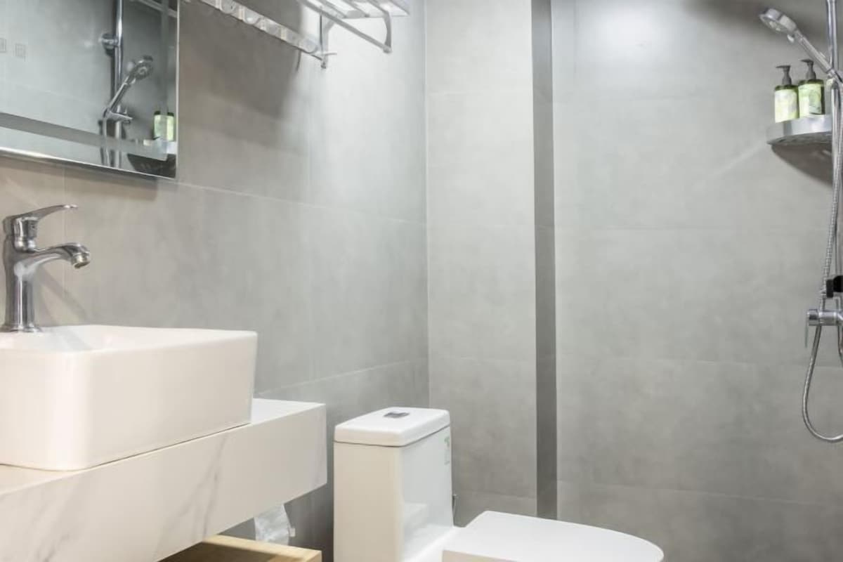 Un baño moderno con lavamanos grande, inodoro y ducha.