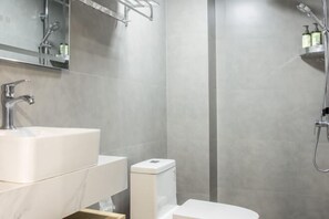Un baño moderno con lavamanos grande, inodoro y ducha.