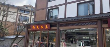 A building with a sign that reads 'Hotel' and a glass entrance.
