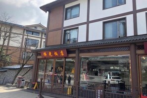 A building with a sign that reads 'Hotel' and a glass entrance. - Foguang Hotel (Emeishan City)