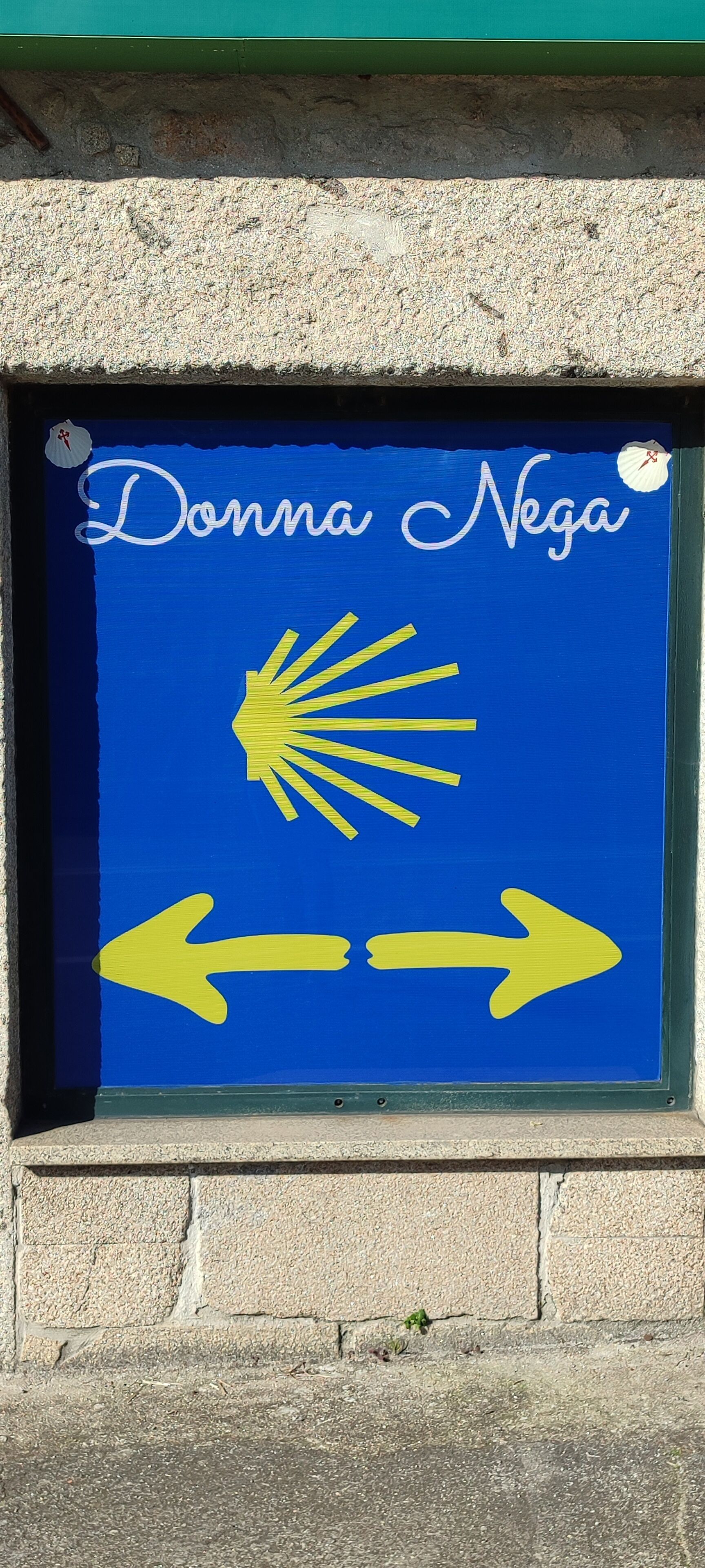Un letrero con el nombre 'Donna Nega' y flechas direccionales.