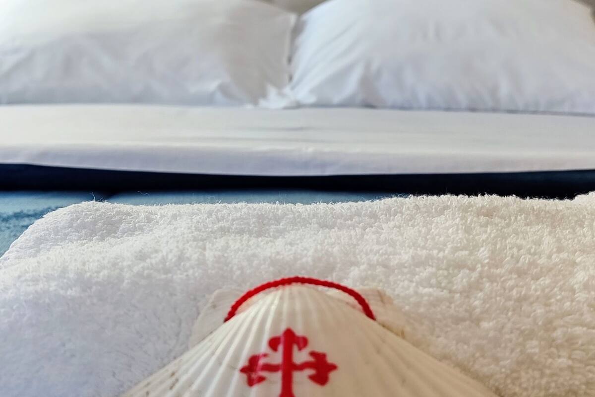 A bed with white bedding and a tufted headboard.