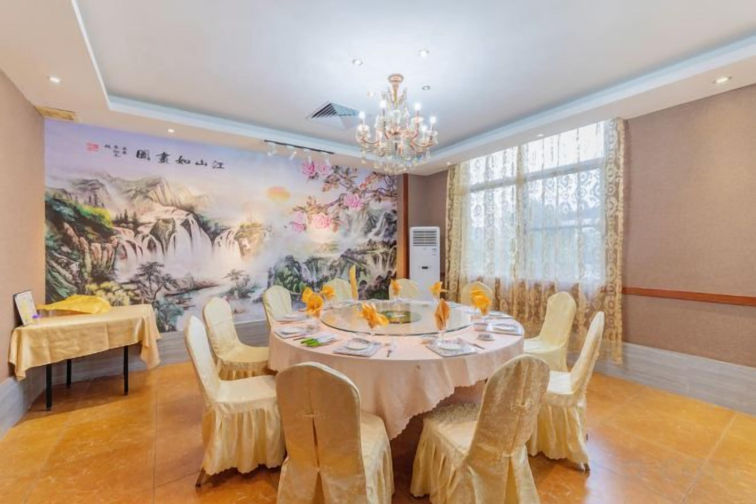A conference room with a round table, chairs, and a mural on the wall.