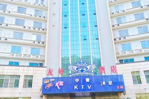 A multi-story building with a prominent blue sign featuring a crown emblem and the text 'KTV'. - Friendly Hotel (Shaoguan Nanhua Temple) (Shaoguan)