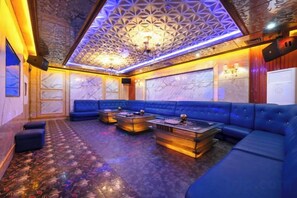 A room with a blue sofa, a coffee table, and a patterned carpet. - Friendly Hotel (Shaoguan Nanhua Temple) (Shaoguan)