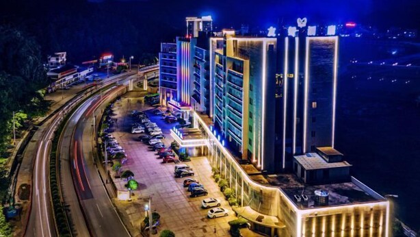 Um hotel moderno com vários andares, estacionamento e vista da região circundante.