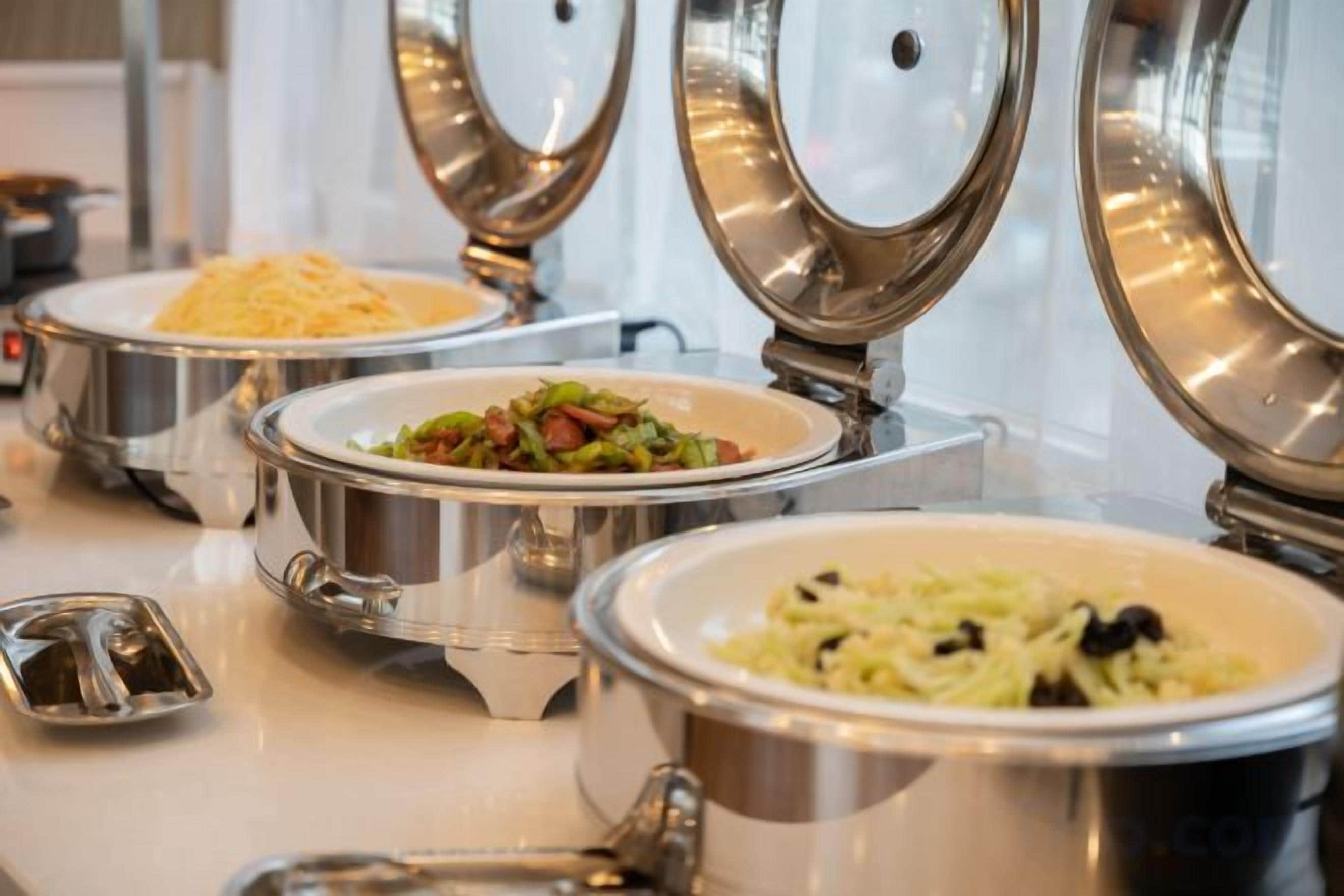 Buffet-style food service with multiple stainless steel serving dishes.