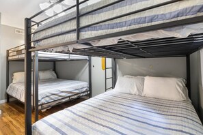 A bunk bed room with two beds, each with a striped bedspread and white pillows. - The Lake Front Oasis in Eldon•Near Bagnell Dam (Eldon)