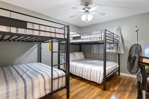 A bunk room with two bunk beds, a ceiling fan, and a standing fan. - The Lake Front Oasis in Eldon•Near Bagnell Dam (Eldon)