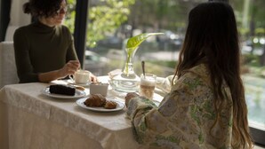 Una mesa de comedor con un plato de postre, un plato de croissant y un vaso de leche.