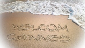 Une plage où l’on a écrit dans le sable : « BIENVENUE À CANNES ».