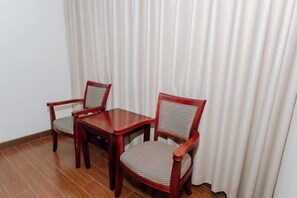 A small room with a wooden table and two chairs. - Meiyamei Hostel (Kaiping)