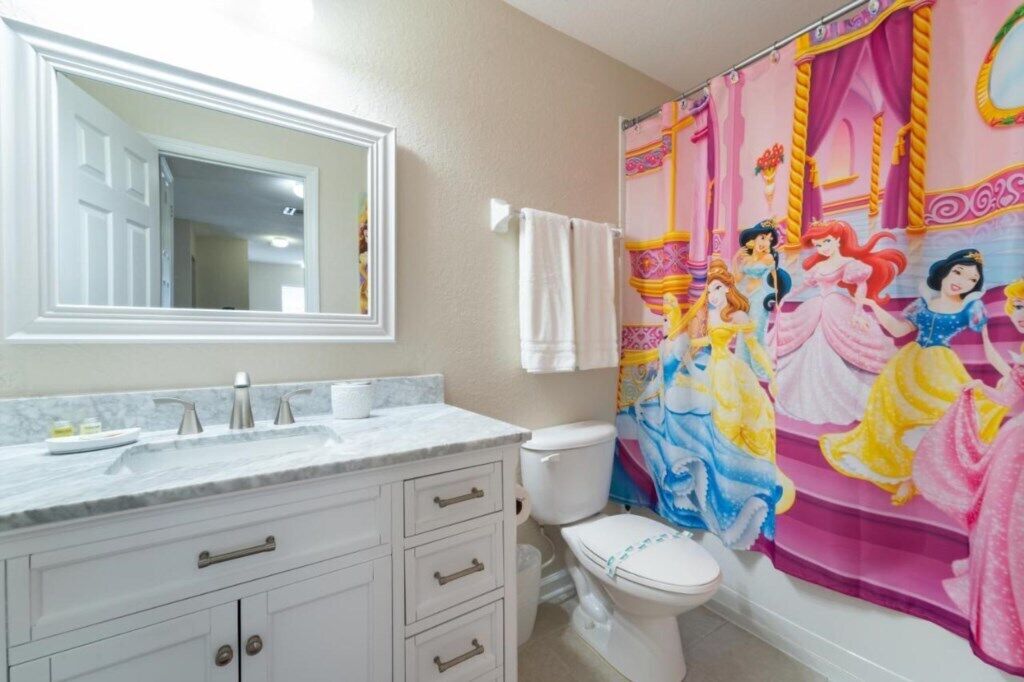 Een badkamer met een witte wasbak, spiegel en toilet.