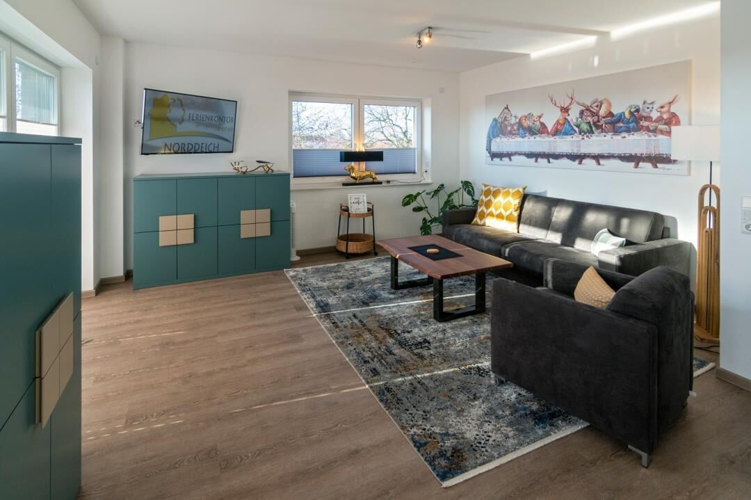Ein modernes Wohnzimmer mit einer Couch, einem Couchtisch und einem Gemälde von 'Das Abendmahl' an der Wand.