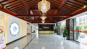 A spacious lobby with a polished marble floor, a reception desk, and a large chandelier. - Lijin Hotel (Lingshan)