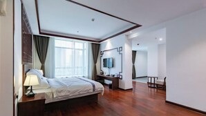 A modern hotel room with a large bed, a desk, a TV, and a chair. - Lijin Hotel (Lingshan)