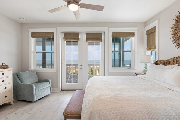 Une chambre à coucher avec un lit, une chaise, une commode et un ventilateur de plafond.